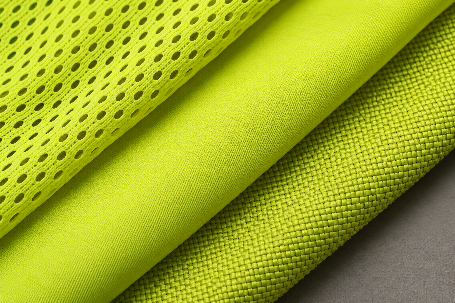 Illustrative textile close-up of mesh, solid knit and Oxford-style woven materials.