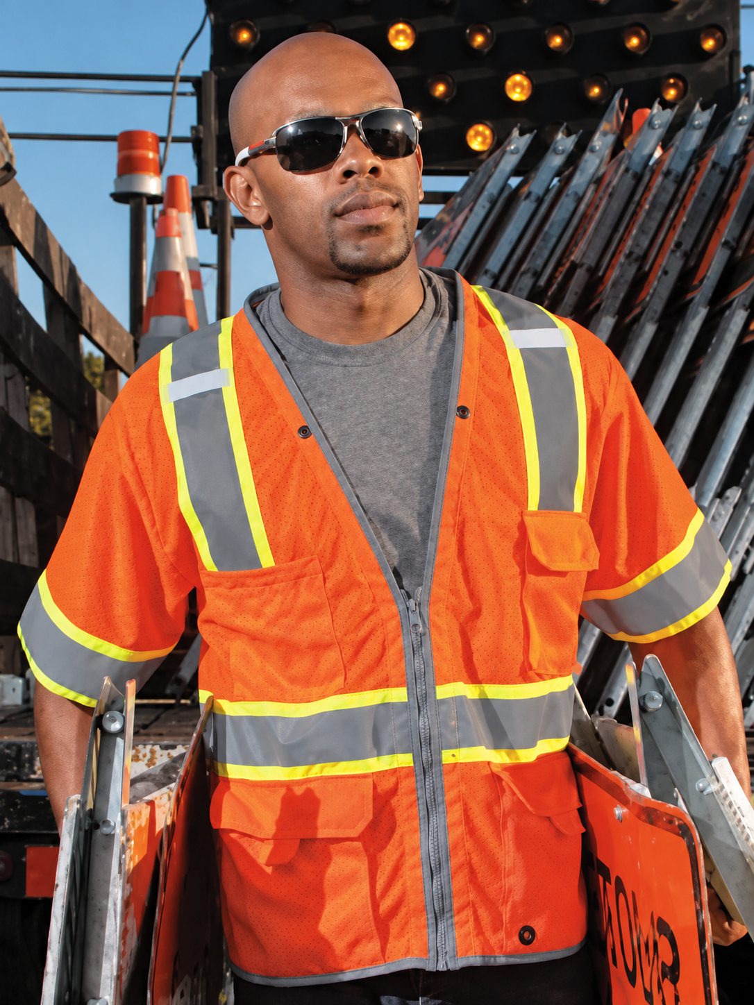 Worker wearing an orange ANSI Class 3 safety vest